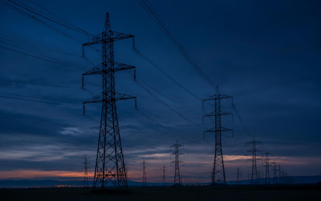 Torres de transmissão de alta tensão ao anoitecer, após um blecaute